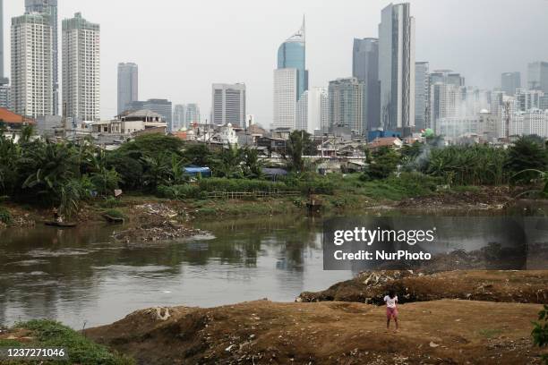 Childrens are seen playing in one of slum area with skyscrapers as background in Jakarta, on December 15, 2021. On December 9, UNICEF released a...