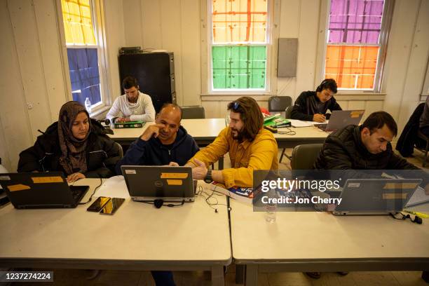 Afghan medical doctors study for American licensure in the computer lab at an Afghan refugee camp at Fort Pickett on December 16, 2021 in Blackstone,...