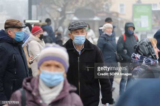 People wearing facemasks as a preventive measure against the spread of coronavirus walk on the street in downtown.
