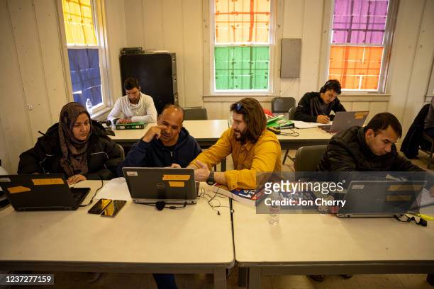 Afghan medical doctors study for American licensure in the computer lab at an Afghan refugee camp at Fort Pickett on December 16, 2021 in Blackstone,...