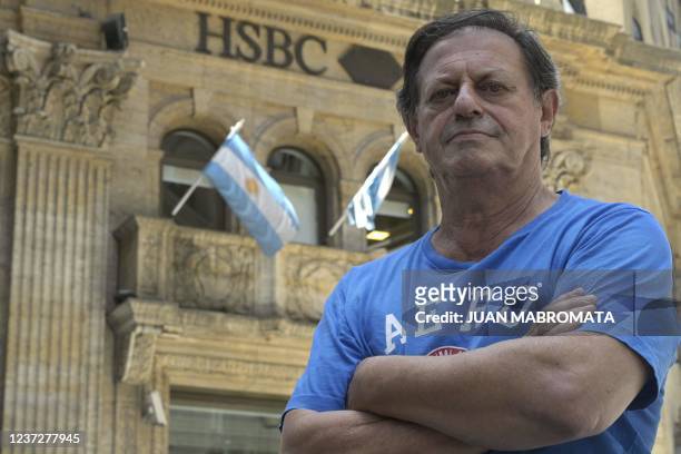 Argentine saver Ricardo Llados --a victim of the 2001 economic crisis-- poses outside the HSBC Bank in Buenos Aires on December 2, 2021 where he had...