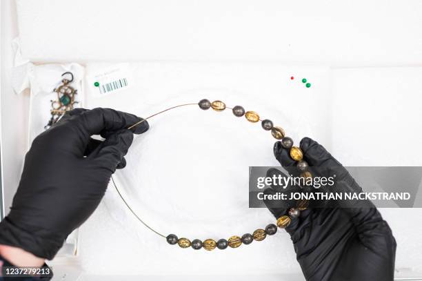 Picture taken on November 24, 2021 shows curator Anni Guttorm as she examines Sami objects which have been recently repatriated to Siida, the Sami...