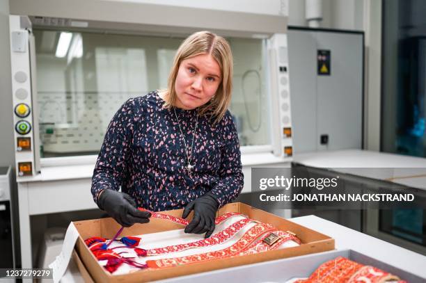 Picture taken on November 24, 2021 shows curator Anni Guttorm as she examines Sami objects which have been recently repatriated to Siida, the Sami...
