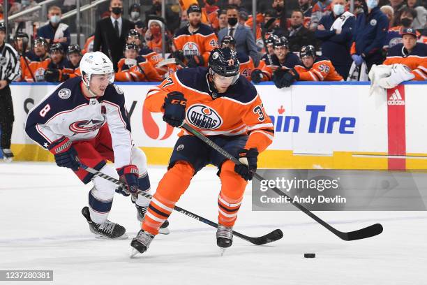 Warren Foegele of the Edmonton Oilers skates with the puck while being pursued by Zach Werenski of the Columbus Blue Jackets on December 16, 2021 at...