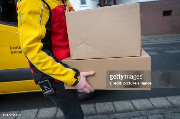 December 2021, Hessen, Ober-Ramstadt: A DHL employee delivers a parcel. Photo: Sebastian Gollnow/dpa