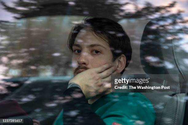 Alex Stow a travel ICU registered nurse, poses for a portrait inside his car after getting off of a 12.5 hour shift at a local hospital in Traverse...