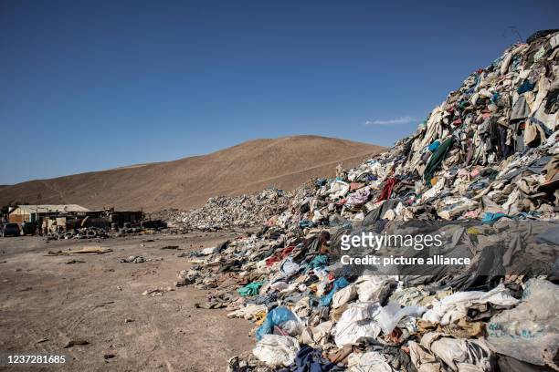 Dpatop - 25 November 2021, Chile, Alto Hospicio: Used clothes sit in a landfill in the desert. In the nearby free trade zone of Iquique 178 tons of...