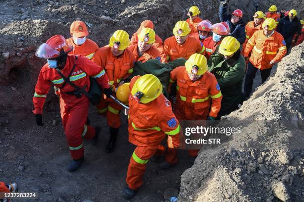 Members of a rescue team transfer a mine worker out of a flooded coal mine in Xiaoyi city, in northern China's Shanxi province on December 17, 2021....