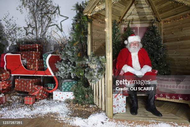 Howard Griffiths dressed as Father Christmas poses for a portrait in Santa's Grotto at Dobbies garden centre near Chesterfield, northern England on...