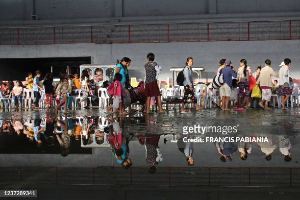 Residents take shelter in a cultural center turned into an evacuation center after Super Typhoon Rai passed in Isabela town of Negros Occidental...