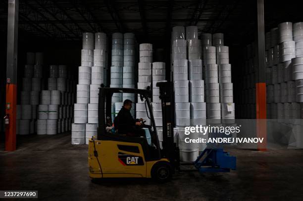 An employee drives a lift truck by barrels of pasteurized maple syrup from one of two maple syrup reserves at the Quebec Maple Syrup Producers...
