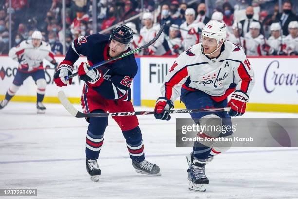 Dominic Toninato of the Winnipeg Jets and John Carlson of the Washington Capitals follow the play down the ice during first period action at the...