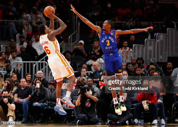 Lou Williams of the Atlanta Hawks shoots as Bones Hyland of the Denver Nuggets defends during the first half at State Farm Arena on December 17, 2021...
