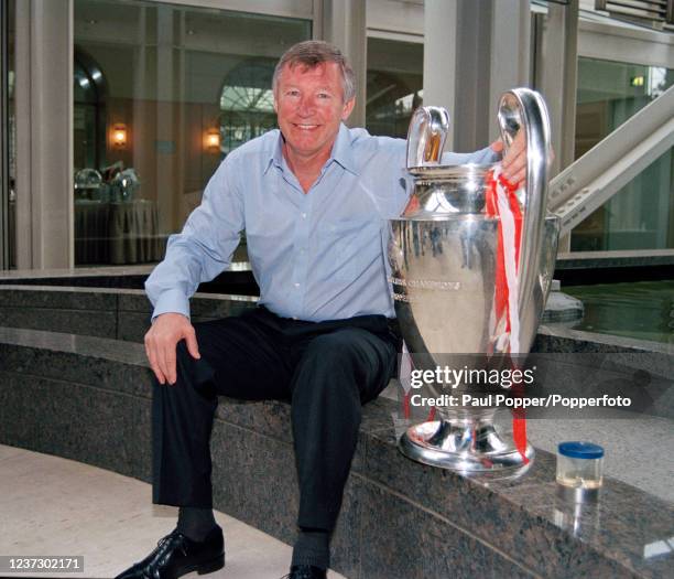 Manchester United manager Alex Ferguson celebrates with the trophy the morning after Manchester United defeated Bayern Munich in the Champions League...