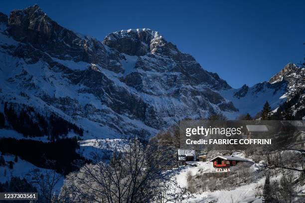 Picture taken on December 18, 2021 shows snow-covered chalets at the bottoms of a mountain in the Swiss Alps in Engelberg.