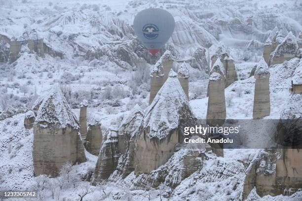 Drone photo shows hot-air balloons gliding above fairy chimneys in snow-covered Cappadocia region, located in Nevsehir province, Turkey on December...