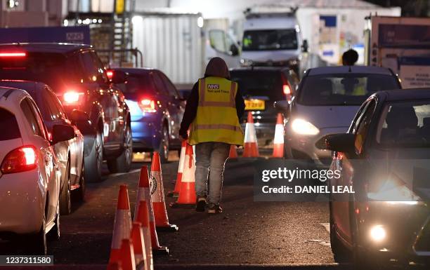 Members of the public travel in their cars as they arrive at, and depart from, a Covid-19 drive-in coronavirus testing centre in London on December...