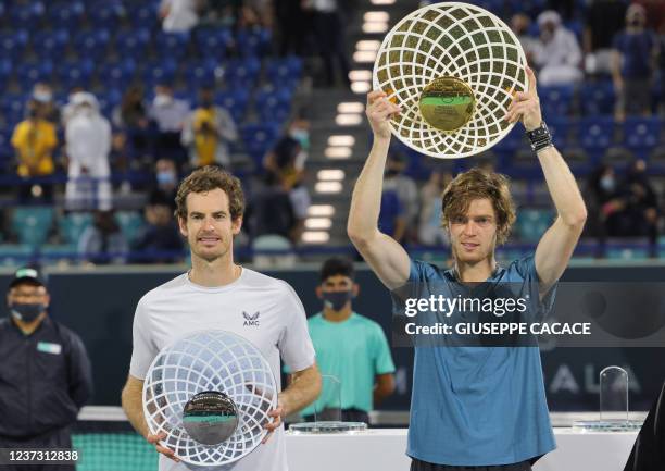 First-place winner Andrey Rublev of Russia holds up his trophy alongside second-place winner Andy Murray of Britain during the awards ceremony after...