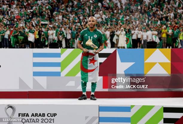 Algeria's forward Yacine Brahimi poses with the golden boot trophy during the FIFA Arab Cup 2021 final football match between Tunisia and Algeria at...