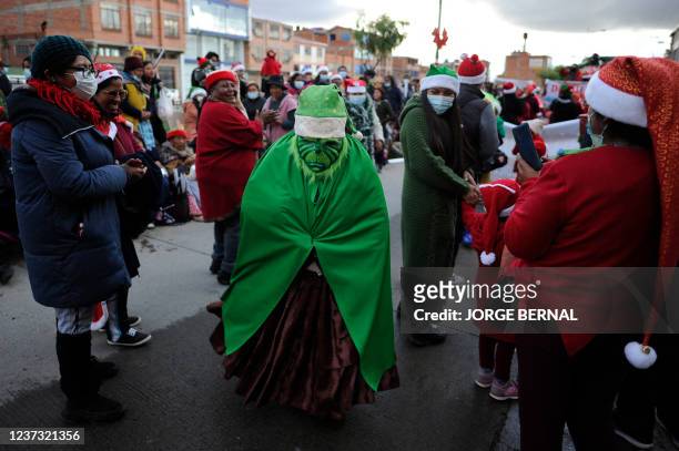 Bolivian Aymara woman disguised as the Grinch takes part in a Christmas parade in El Alto, Bolivia on December 18, 2021.