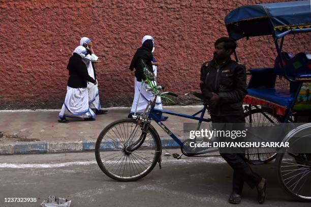 Nuns from the Catholic Order of the Missionaries of Charity walk through a street after casting their vote at a polling station during the municipal...