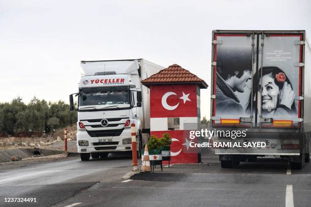 This picture taken at Syria's northern border with Turkey shows Turkish lorries driving through a checkpoint manned by the Turkish-backed Free Syrian...