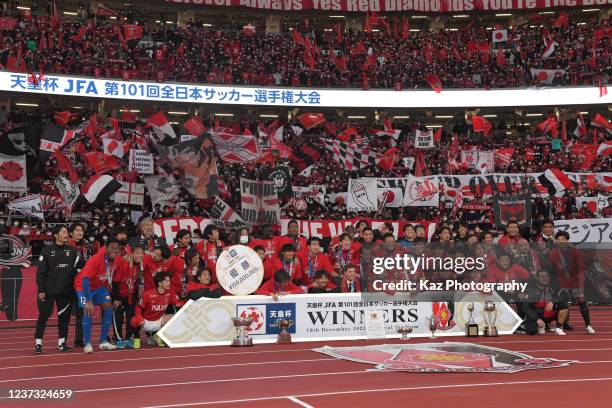 Urawa Red Diamonds players pose with Emperor's Cup and background of supporters during the 101st Emperor's Cup final between Urawa Red Diamonds and...