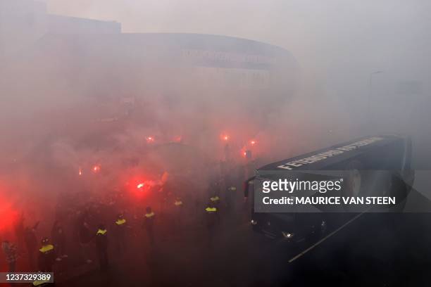 Bus of Feyenoord's players arrive as fans light flares outside De Kuipp stadium in Rotterdam on December 19, 2021 ahead of the Dutch Eredivisie...