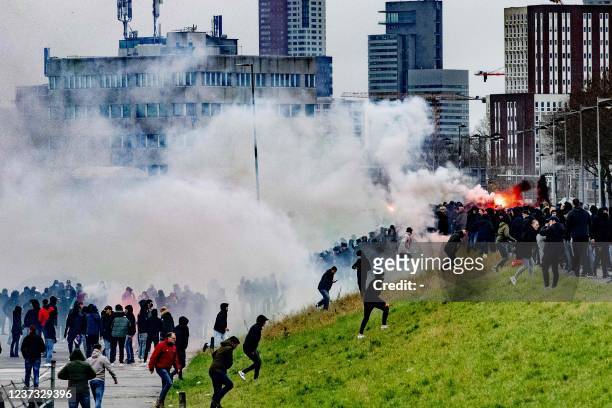 Supporters of Feyenoord light flares outside De Kuip after attacking with smoke bombs a fake Ajax bus, a trick prepared to let the real bus with Ajax...