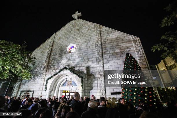 Crowd of Palestinian Christians celebrate before lighting the Christmas tree in the church of the holy family.