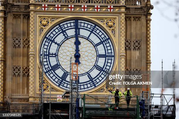Workers remove the scaffolding from the restored west dial of the clock on Elizabeth Tower, commonly known by the name of the bell Big Ben, at the...