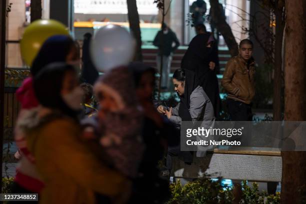 An Iranian woman sits on a street-side in the city of Isfahan, 450 km south of Tehran, at night on December 14, 2021. A spokesman for Isfahan...
