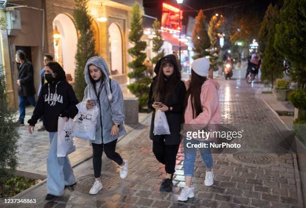 Iranian young women walk along a street near a historical church in the city of Isfahan, 450 km south of Tehran, at night on December 14, 2021. A...