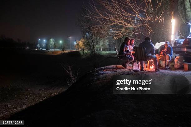 An Iranian man puffs on a hookah as he and his friends sit on a dried-up Zayandeh Rud river riverside in the city of Isfahan, 450 km south of Tehran,...