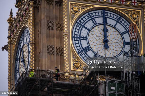 Workers remove sections of scaffolding surrounding Elizabeth Tower, commonly known as Big Ben, as renovation works continue on December 20, 2021 in...