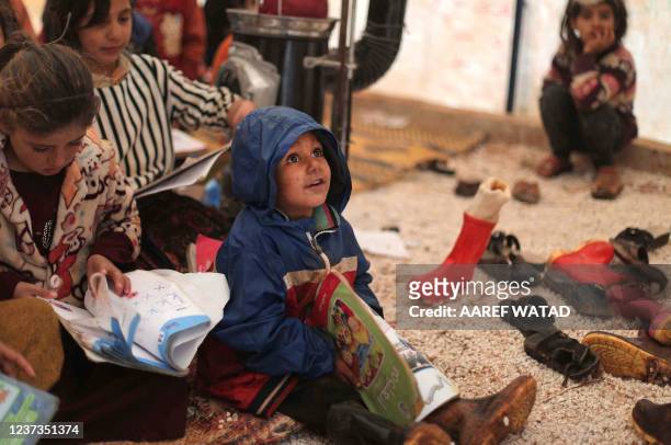 Children attend class in make-shift classrooms at a camp for the displaced by the village of Killi, near Bab al-Hawa by the border with Turkey, in...