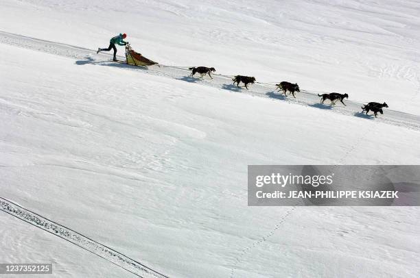 Un Musher et son attelage sont photographiés lors de la première étape du "Trophée la Grande Odyssée", le 14 janvier 2006 sur le plateau du Mont...