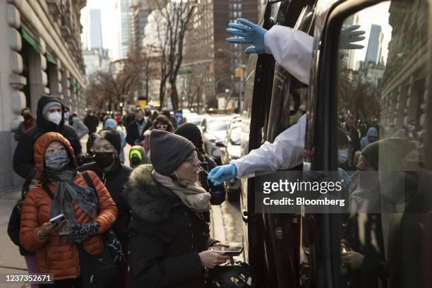 Healthcare workers administers a Covid-19 test at a mobile testing site in the Upper West Side neighborhood of New York, U.S., on Sunday, Dec. 19,...