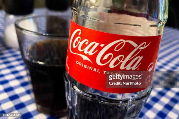 Coca-Cola logo is seen on the bottle in a restaurant in Krakow, Poland on June 14, 2021.