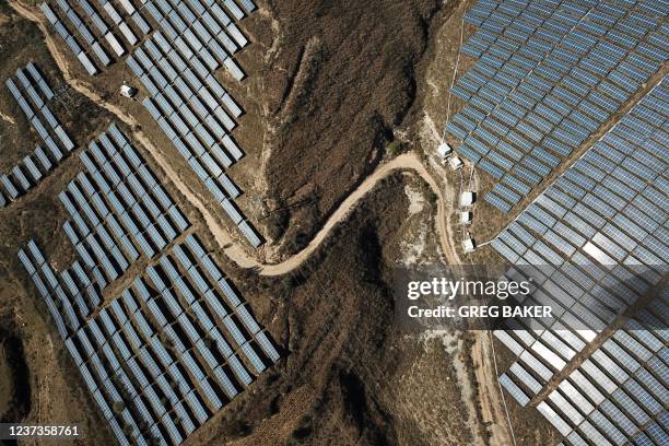 This photo taken on October 22, 2021 shows solar panels on hillsides at Qu village in Baoding in China's northern Hebei province. - China is the...