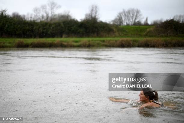 Susan Moate, a regular wild swimmer, swims in the river Ouse in Lewes, southern England on December 6, 2021. - "An open sewer", is how surfer Stu...