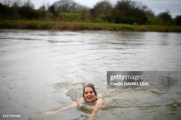 Susan Moate, a regular wild swimmer, swims in the river Ouse in Lewes, southern England on December 6, 2021. - "An open sewer", is how surfer Stu...