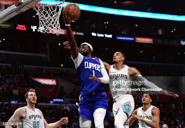 Reggie Jackson of the Los Angeles Clippers goes up for layup against Dejounte Murray of the San Antonio Spurs during the first half of the game at...