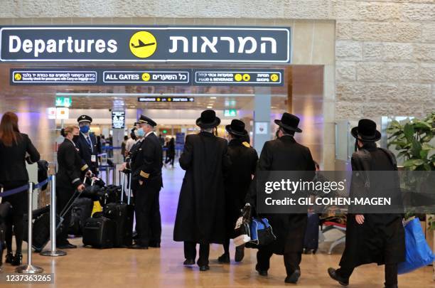 Ultra-Orthodox Jewish travellers walk with their luggage ahead of their departing flights at Israel's Ben Gurion Airport in Lod, east of Tel Aviv, on...