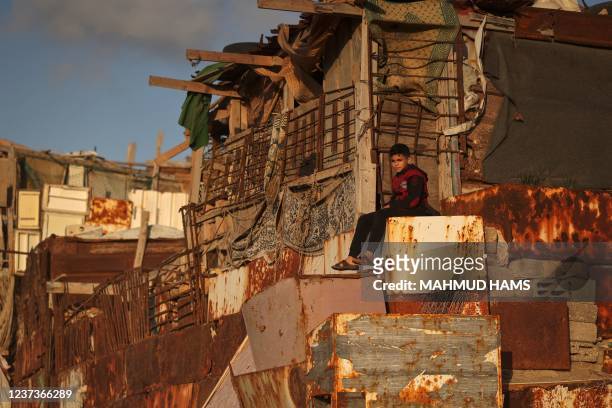 Palestinian boy sits outside his makeshift home on the beach at the al-Shati camp for Palestinian refugees in Gaza City on December 21, 2021.