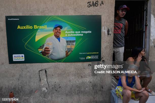 An advertisement of "Auxilio Brasil" -the federal government's social assistance program to help low-income families- is seen posted on the wall of a...