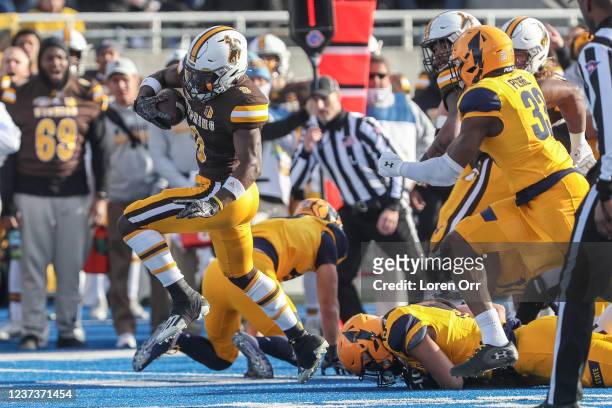 Running back Titus Swen of the Wyoming Cowboys breaks through the line during first half action against he Kent State Golden Flashes at the Famous...