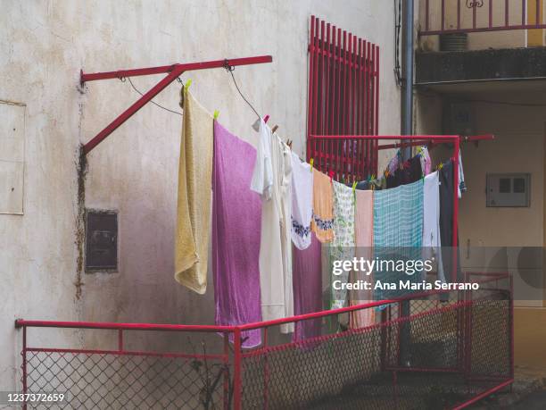 ropa tendida seca en un tendedero en la calle de un pueblo - rope lava stock pictures, royalty-free photos & images