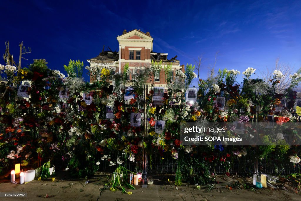 Flowers and photos of those who died are left at a makeshift...