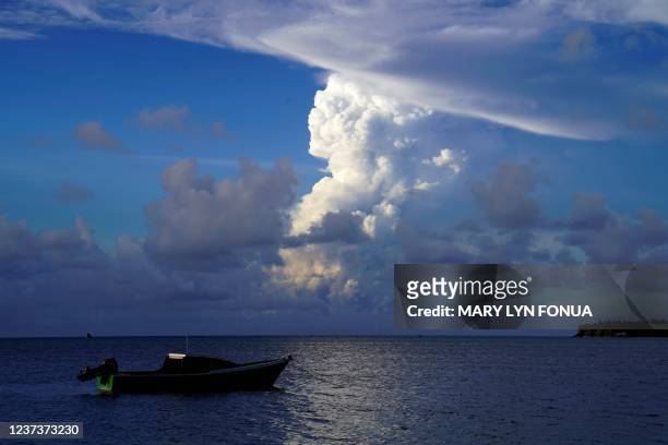 This picture taken on December 21, 2021 shows white gaseous clouds rising from the Hunga Ha'apai eruption seen from the Patangata coastline near...